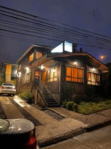 a house with a sign on the top of it at Hostal y Cabañas Mirando al Mar in Puerto Montt