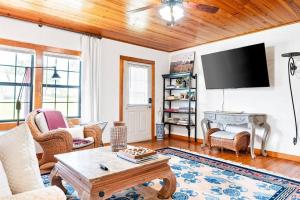 ein Wohnzimmer mit Sofa und Fernseher in der Unterkunft Sweet Tea Cottage-Cullman in Hanceville