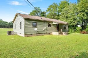 ein grünes und weißes Haus mit einem Hof in der Unterkunft Sweet Tea Cottage-Cullman in Hanceville