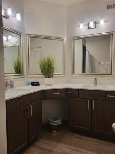 uma casa de banho com dois lavatórios e dois espelhos em Downtown Dallas 2bd free parking em Dallas
