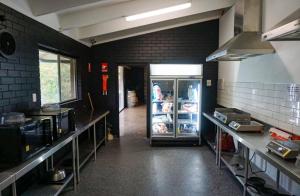 a kitchen with a refrigerator in the middle of a room at Halls Gap Lakeside Tourist Park in Halls Gap