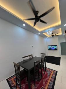 une salle à manger avec une table, des chaises et un ventilateur de plafond dans l'établissement HomestayHA Taman Lembah Bujang FOR MAHRAM ONLY, à Bedung