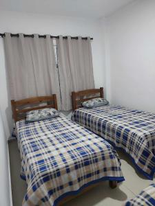 two beds sitting next to each other in a room at Apartamento belvedere do lago in Serra Negra