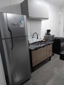 una cucina con frigorifero in acciaio inossidabile e lavandino di Apartamento belvedere do lago a Serra Negra