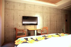 京都市にあるHotel Legasta Kyoto Higashiyama Sanjoのベッドルーム1室(ベッド1台、壁にテレビ付)