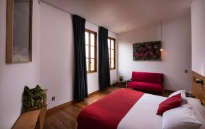 ein Schlafzimmer mit einem Bett und einem roten Stuhl in der Unterkunft Fauna Hotel in Valparaíso