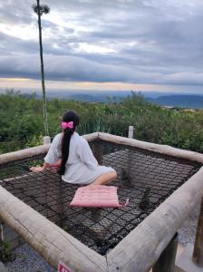 a woman sitting on top of a cage at Chalé Formoso - Chalé Romântico com Hidromassagem in Serra de São Bento