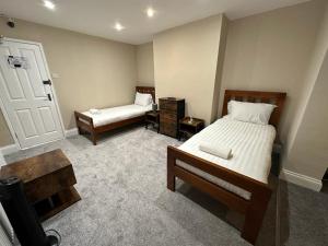 a small bedroom with two beds and a door at Inn By The Sea, Portsmouth - EN SUITE Rooms with or without Sea View in Portsmouth