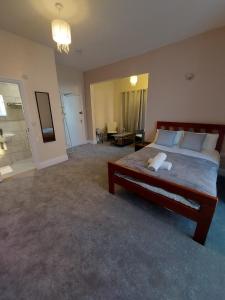 a bedroom with a large bed and a living room at Inn By The Sea, Portsmouth - EN SUITE Rooms with or without Sea View in Portsmouth