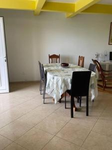 a dining room table with chairs and a white table cloth at VILLA NATURE in Baie-Mahault