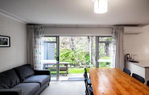 sala de estar con sofá y mesa de madera en Ripple Rotorua, en Rotorua