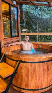 a man in a hot tub in a cabin at Skyline Ecoliving Santa Elena in Santa Elena
