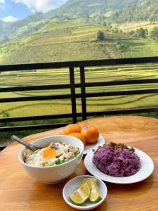 a table with a bowl of oatmeal and a plate of food at Dong Suoi H'mong Homestay & Bungalow in Mù Cang Chải