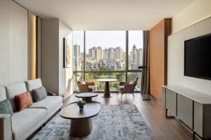 a living room with a couch and a tv at Sheraton Xuzhou in Xuzhou
