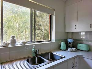a kitchen with a sink and a window at CHILL-OUT BEACHSIDE - Main Beach Forster in Forster +33 photos