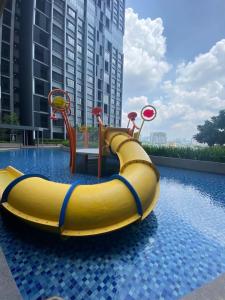 a yellow water slide in a swimming pool at Millerz Square Mid Valley, Old Klang Road in Kuala Lumpur