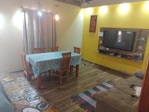 - un salon avec une table et une télévision dans l'établissement Casa vila da fumaça, à Resende