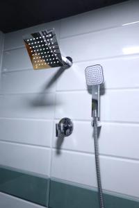 a shower with a shower head on a wall at Dormitory Hub in Mumbai