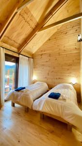 1 dormitorio con 2 camas en una habitación de madera en Casa Huilo, en Neltume