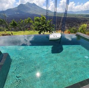 a boat on a swing over a pool of water at Sari Sky Bali in Kubupenlokan