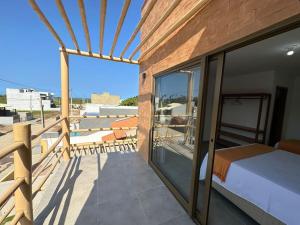 um quarto com uma varanda com uma cama e uma vista em Casa Tapera - Porto de Pedras/AL em Pôrto de Pedras