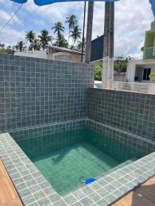 a hot tub with green tile on a house at Casa Tapera - Porto de Pedras/AL in Pôrto de Pedras