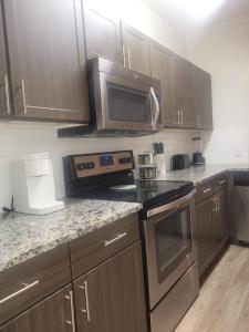 a kitchen with stainless steel appliances and wooden cabinets at Downtown Dallas 2bd free parking in Dallas