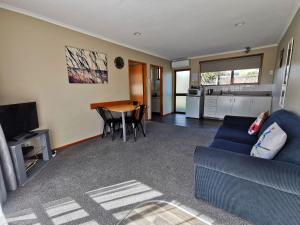 a living room with a blue couch and a table at Broadview Motel in Cheviot