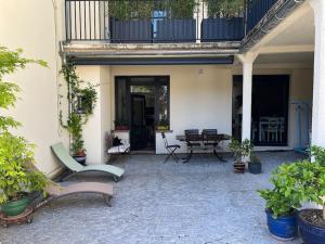 eine Terrasse mit einem Tisch und Stühlen sowie einem Balkon in der Unterkunft Charmant appartement en pierres in Bourgoin