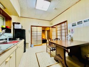eine Küche mit einem Tisch und einer Arbeitsplatte in der Unterkunft ワイルドライフ　森風 in Hiki