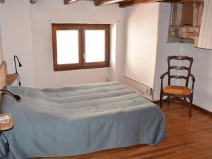 Bett in einem Zimmer mit einem Stuhl und einem Fenster in der Unterkunft Chalet Pralognan-la-Vanoise, 3 pièces, 4 personnes - FR-1-464-219 in Pralognan-la-Vanoise