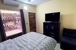 a bedroom with a bed and a flat screen tv at Villa con Alberca Privada, 3 Recamaras 6 Personas in La Paz