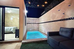 a pool in a room with a couch and a bed at Villa con Alberca Privada, 3 Recamaras 6 Personas in La Paz