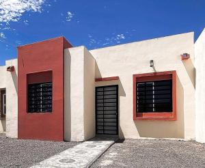 a red and white building with two garage doors at Villa con Alberca Privada, 3 Recamaras 6 Personas in La Paz