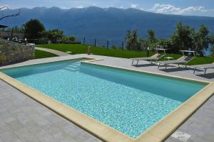 une piscine avec deux chaises longues à côté dans l'établissement Apartment in Tignale with Lake Garda Views, à Tignale
