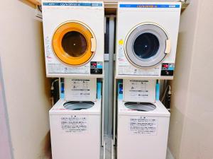 drei Waschmaschinen in einem Regal in einem Zimmer in der Unterkunft エスタールゴヤ in Tomari