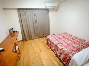 1 dormitorio con 1 cama y vestidor en エスタールゴヤ en Tomari