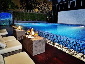 una piscina con mesa y copas de vino en Sky dome resotel en Bangkok