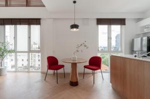 a kitchen with a table and two red chairs at M Village Hai Bà Trưng in Ho Chi Minh City