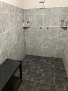 a bathroom with a tiled shower with a table at Farm Lodge La Cabaña 