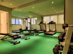 a gym with several treadmills and machines in a room at Hotel Benilde Maison De La Salle in Manila
