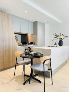 - une cuisine avec une table et des chaises dans la chambre dans l'établissement Minutes from Melbourne CBD - FREE Parking, à Footscray