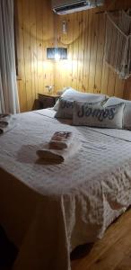 1 dormitorio con cama blanca y pared de madera en Cristino Multiespacio en Goya