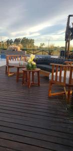 a wooden deck with benches and a table with flowers at Cristino Multiespacio in Goya