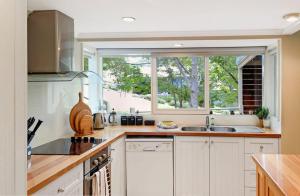 a kitchen with white cabinets and a large window at Mirimvale - Base of Mt Buller - Sleeps 14 in Merrijig