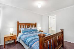 a bedroom with a wooden bed and a window at Mirimvale - Base of Mt Buller - Sleeps 14 in Merrijig