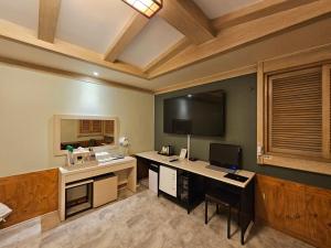 Cette chambre comprend un bureau avec un ordinateur et une télévision. dans l'établissement Hotel G7 Daejeon, à Daejeon