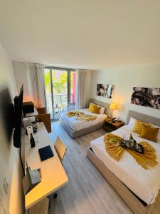 ein Hotelzimmer mit 2 Betten, einem Schreibtisch und einem Schreibtisch in der Unterkunft Beachwalk Resort & Condos in Hallandale Beach