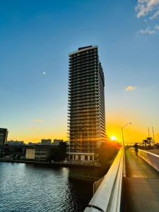 a tall building next to a river with the sunset at Beachwalk Resort & Condos in Hallandale Beach