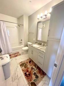 a bathroom with a sink and a toilet and a mirror at Luxury 2-Bed 2 Bath Apartment in King of Prussia